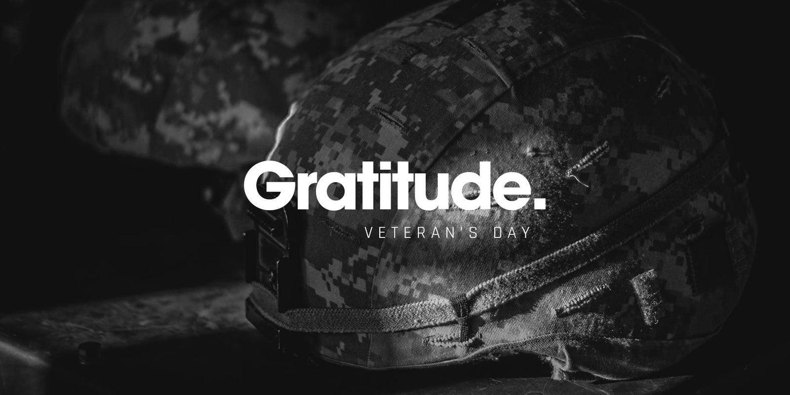 Military combat helmet resting on a dark surface in black and white