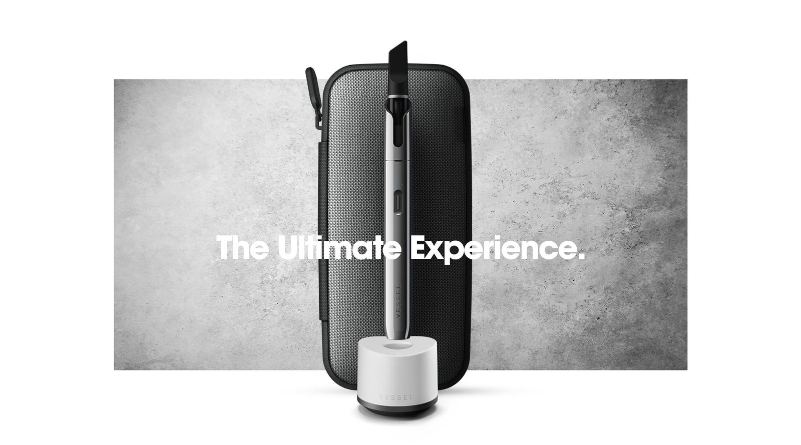 Vessel Vista Edge Slate 510 thread pen-style battery in white base charger with Gunmetal Rover carry case against stone backdrop